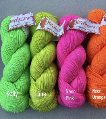 Vier Stränge Herzfasern No. 11 in kräftigen Neonfarben: sattes Grün (Kelly), spritziges Lime, knalliges Neon Pink und leuchtendes Neon Orange – zusammengestellt als Set für den Westknits MKAL 2025.